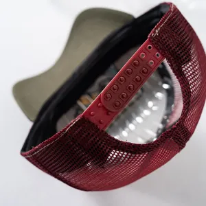 Dettaglio della chiusura snapback e della rete rossa traspirante sul cappello trucker