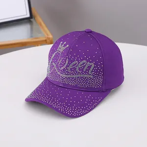 Détail de la casquette violette avec lettrage Queen en strass et emblème de couronne brillant