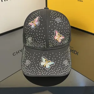Close-up of black baseball cap with sparkling rhinestone butterfly appliques and embroidery