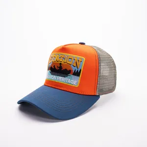 Dettaglio della rete traspirante e del ricamo del tramonto sul cappello trucker bicolore