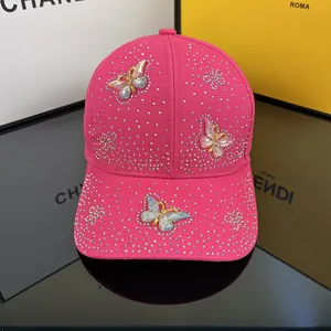 Detail of pink baseball cap featuring sparkling rhinestones and colorful 3D butterflies