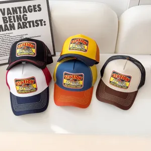 Gruppo di cappellini trucker vintage con patch motocross esposti su un divano