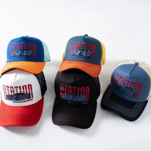 Dettaglio flat lay di una collezione di cappelli trucker colorati con stampe vintage