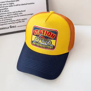 Dettaglio del ricamo Station Motocross su cappello trucker in mesh giallo