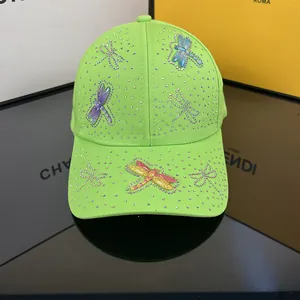 Close-up of neon green baseball cap featuring 3D dragonflies and colorful rhinestones