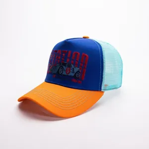 Dettaglio della toppa ricamata su un cappellino trucker in rete bicolore con visiera arancione