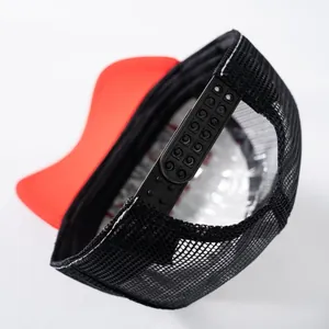 Dettaglio della chiusura snapback regolabile e della rete nera sul cappello trucker