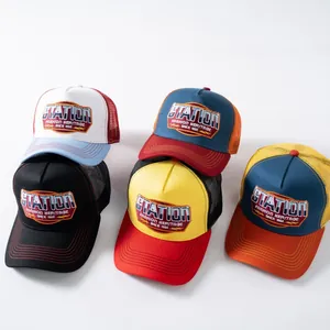 Dettaglio di cinque cappellini trucker in mesh in vari colori con toppa station