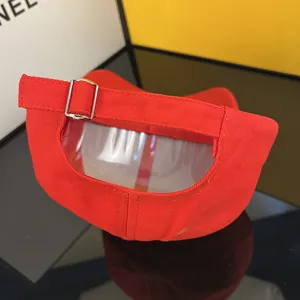 Detail of red baseball cap back showing silver metal buckle and adjustable strap