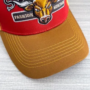 Dettaglio macro del ricamo del toro e cuciture sul cappellino trucker rosso vintage