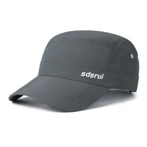 Detail of dark grey quick-dry flat cap showing side logo and metal ventilation eyelets