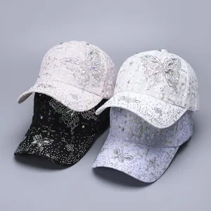 Detail of four lace baseball caps featuring sparkling rhinestone butterflies in multi-colors