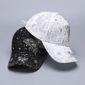Detail of lace baseball caps with rhinestone butterfly patterns in black and white