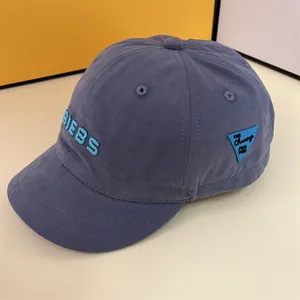 Detail of blue-grey cotton baseball cap with blue 3D BIEBS embroidery and side badge