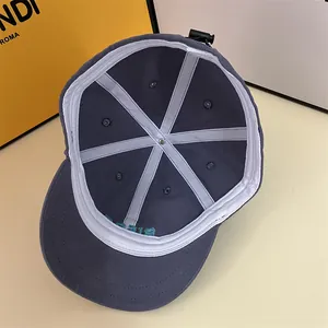 Detail of grey cotton baseball cap interior featuring white reinforced seams and air vents