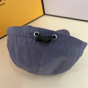 Detail of adjustable drawstring closure with metal eyelets on a blue-grey baseball cap