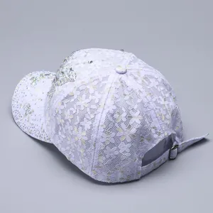 Close-up of floral lace texture and sparkling rhinestones on the baseball cap