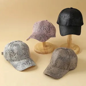 Detail van baseballpetten met slangenprint en kunstmatige python-textuur in diverse kleuren