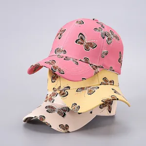 Detailed view of canvas baseball caps with elegant butterfly print in pink and yellow