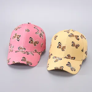 Detailed view of pink and yellow butterfly print baseball caps with leopard wing patterns