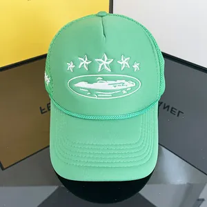 Detail shot of neon green mesh trucker hat featuring embroidered stars on black surface