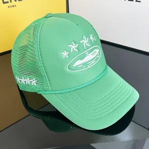Green mesh trucker hat with star embroidery and rope detail on a reflective surface