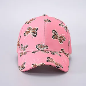 Detail shot of the pink baseball cap featuring intricate butterfly prints and curved brim