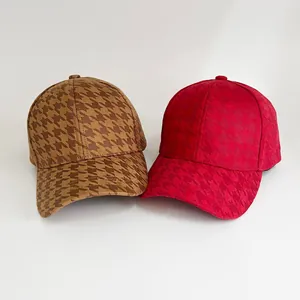 Detailed view of red and brown houndstooth baseball caps with textured fabric and six-panel design