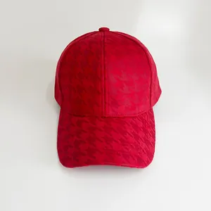 Detail of red houndstooth baseball cap showing textured fabric and six-panel crown