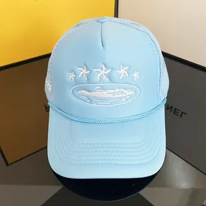 Close-up of light blue trucker hat featuring white star embroidery and mesh back details