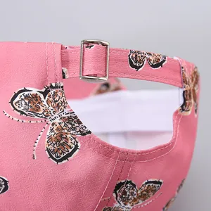 Detail of pink butterfly baseball cap showing silver metal buckle and adjustable strap