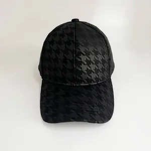 Detailed top view of a black houndstooth baseball cap with textured fabric and classic 6-panel design