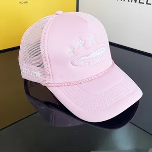 Detailed side view of pink trucker hat featuring white star embroidery and mesh panels
