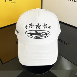 Detail of white trucker hat featuring black star embroidery and breathable mesh panels