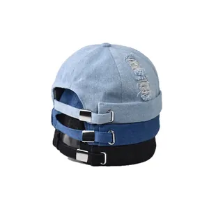 Tre colori di cappelli docker in denim lavato con fibbie metalliche su sfondo bianco