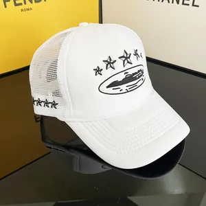 Detailed view of white trucker hat with black star embroidery and mesh panels