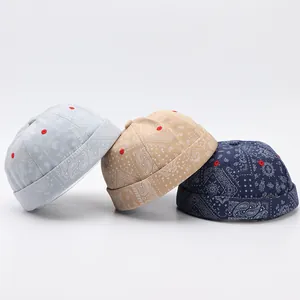 Dettaglio di cappelli miki in cotone con motivo paisley in azzurro, beige e blu notte