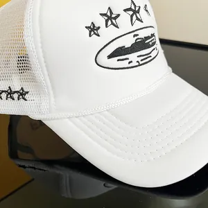 Close-up of white mesh trucker hat featuring black embroidered stars and breathable panels
