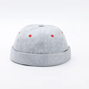 Dettaglio del cappello miki blu con motivo paisley e occhielli ricamati rossi