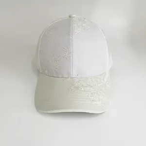 Detailaufnahme einer weißen Baseballkappe mit eleganten floralen Stickereien in Weiß