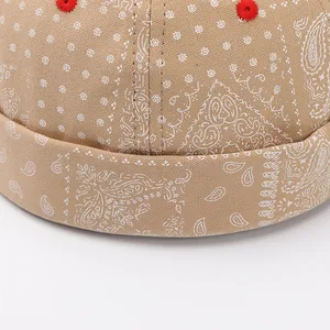 Dettaglio macro del cappello docker kaki con motivi paisley e occhielli rossi