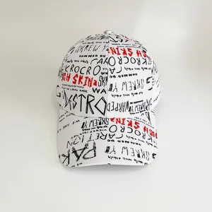Close-up of white canvas baseball cap featuring black and red graffiti letter prints
