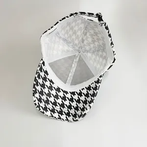 Detail of internal lining and 100% polyester label on houndstooth baseball cap