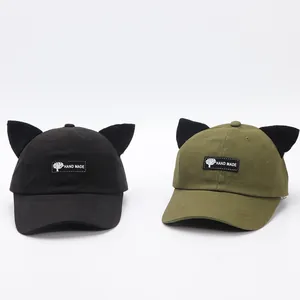 Dettaglio delle orecchie da gatto su berretti da baseball neri e verde oliva