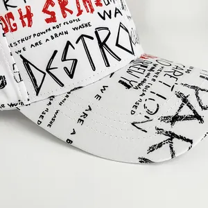 Detailed close-up of graffiti-style letter prints on a white cotton baseball cap