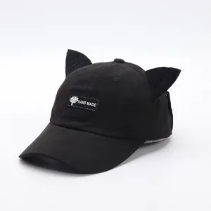Dettaglio cappellino in cotone nero con orecchie di gatto e etichetta Hand Made