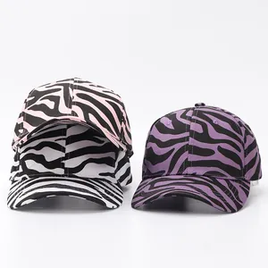 Detalle de textura de gorras de béisbol con estampado de cebra en rosa, blanco y púrpura