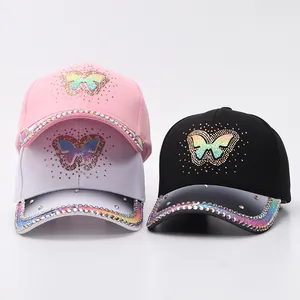 Close-up of rhinestone butterfly baseball caps in pink, white, and black colors