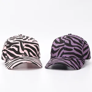 Detalle de gorras de béisbol con estampado de cebra en rosa y púrpura sobre blanco