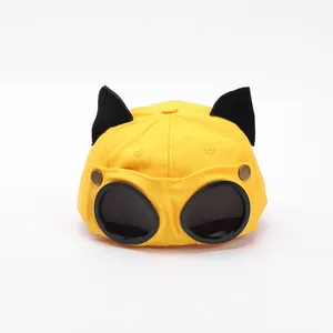 Dettaglio del cappello da pilota giallo con orecchie di gatto nere e occhiali integrati